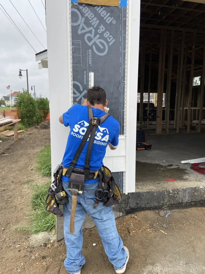 Sousa Roofing & Siding crew member installing vinyl siding
