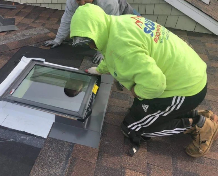 Sousa Roofing crew member installing a roof skylight